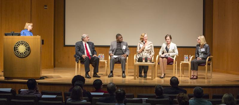 six people in discussion on stage
