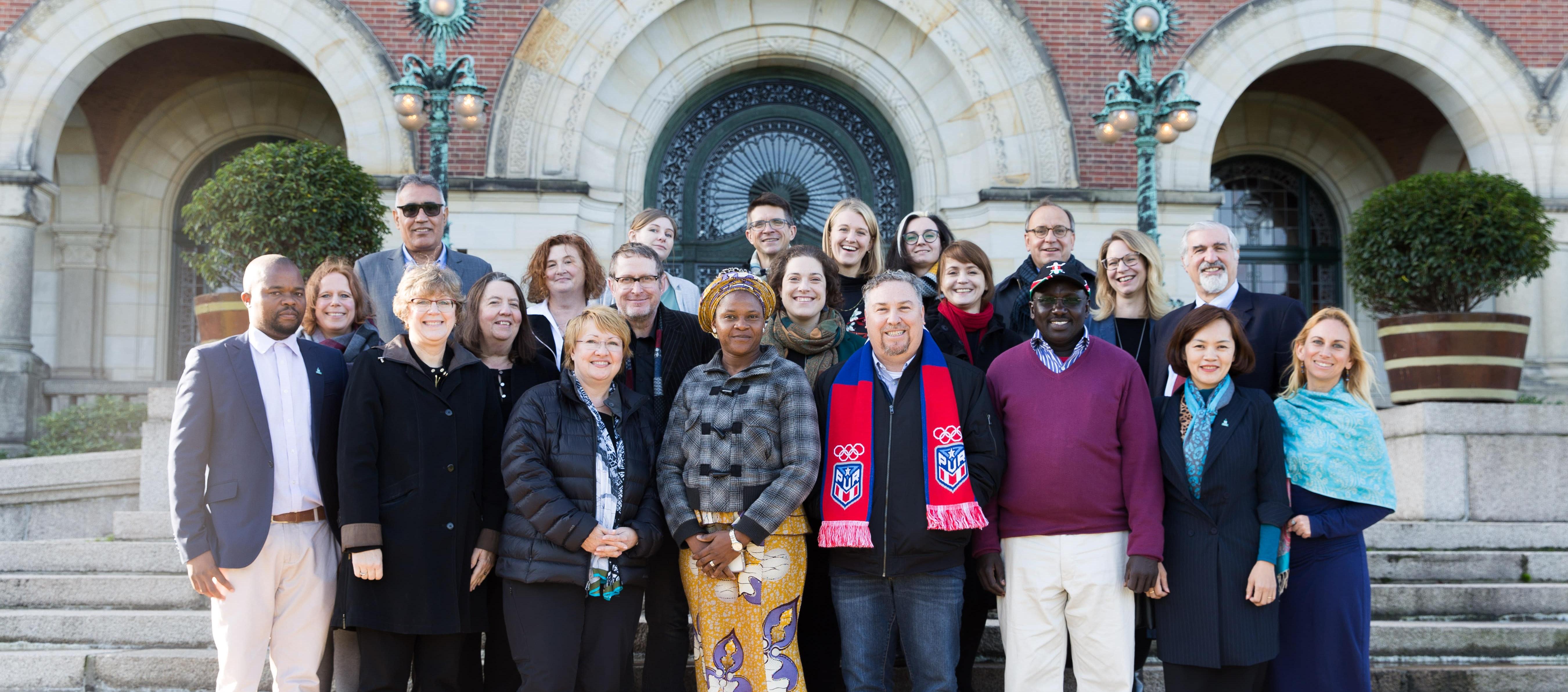 Group of people stand together on the steps of a building. Image by Charlotte Hooij