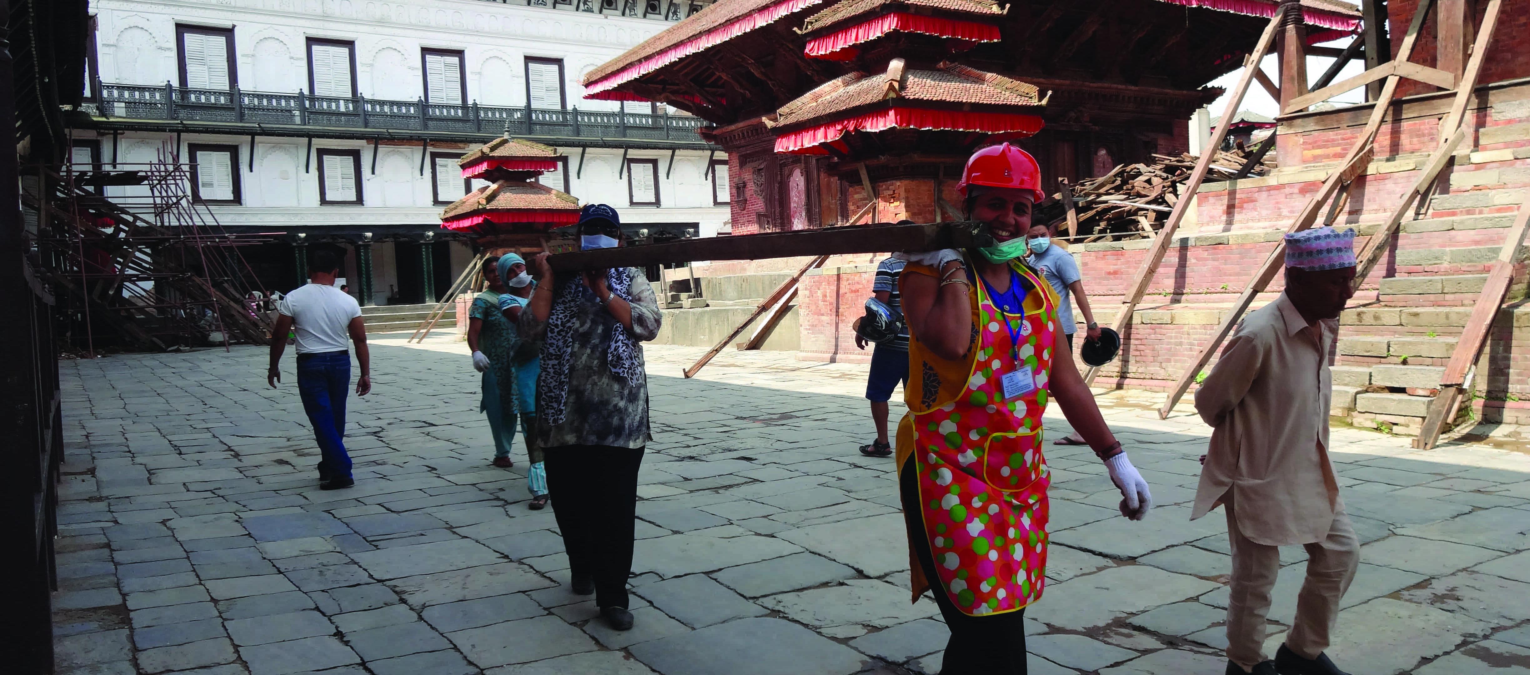 two women carry a beam in Nepal 