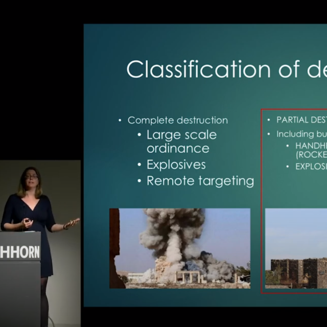 woman in black dress stands at podium on screen is Classification of Destruction