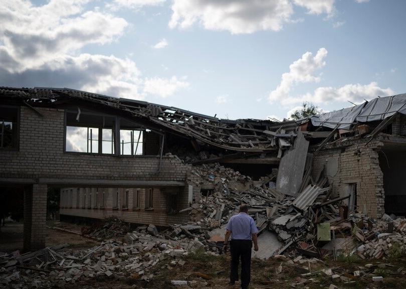 Oleksandr Pishchyk, a school director, stands in front of the school library that was destroyed by shelling in Kupiansk, Ukraine, Aug. 23, 2023.