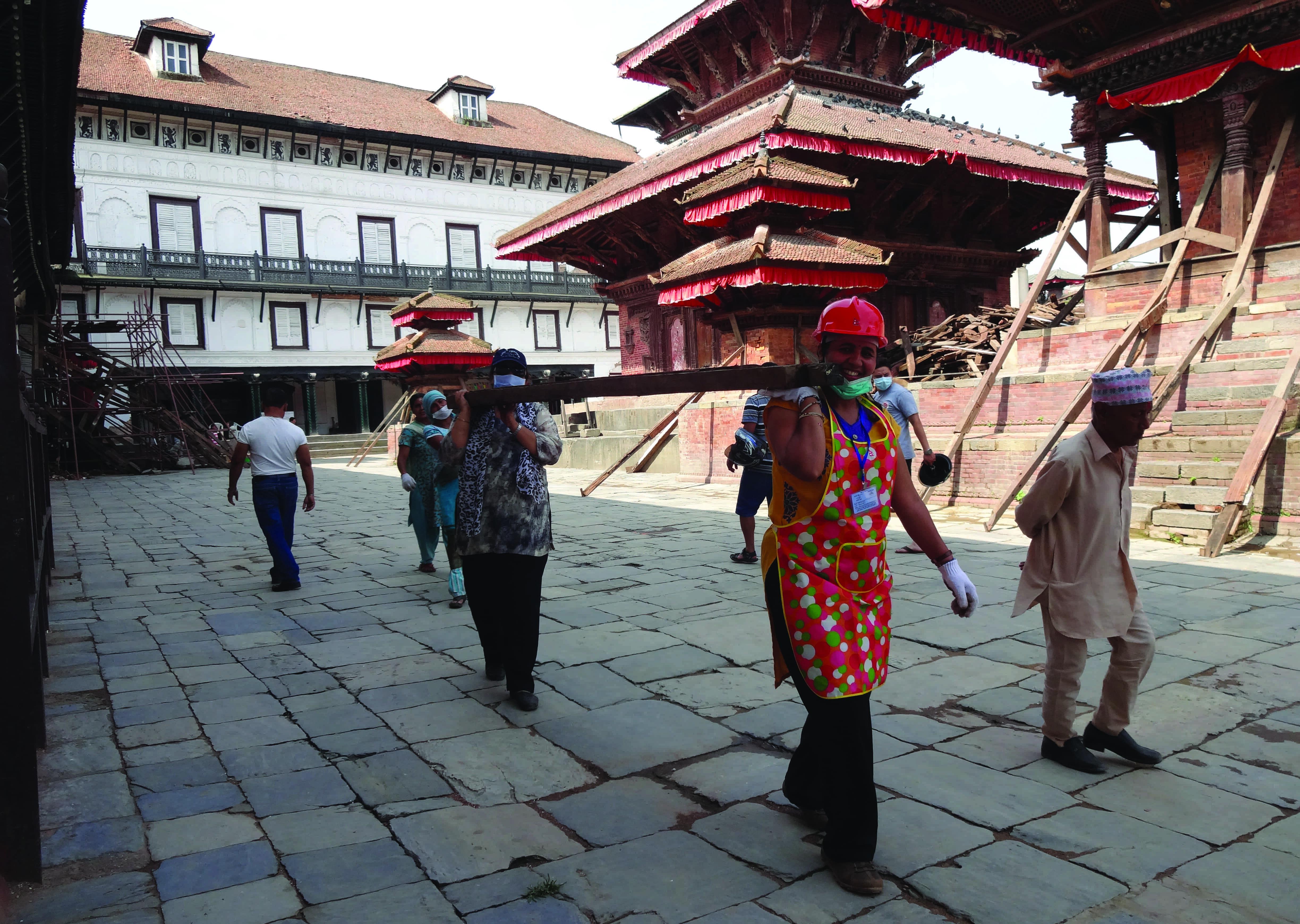 two women carry a beam in Nepal 