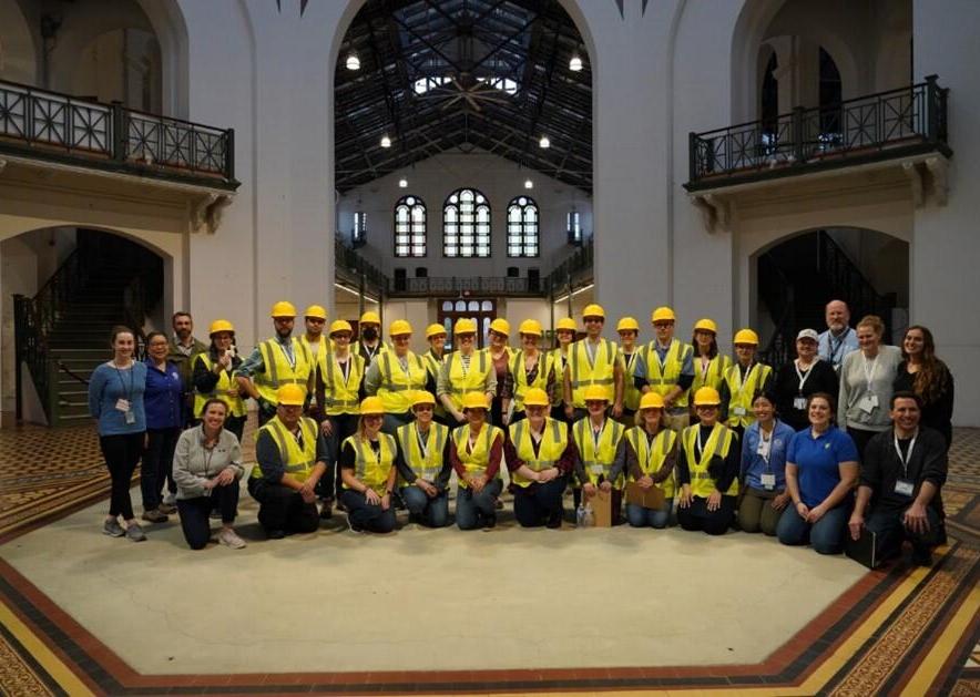 group of people in yellow vests and hardhats in old Smithsonian building