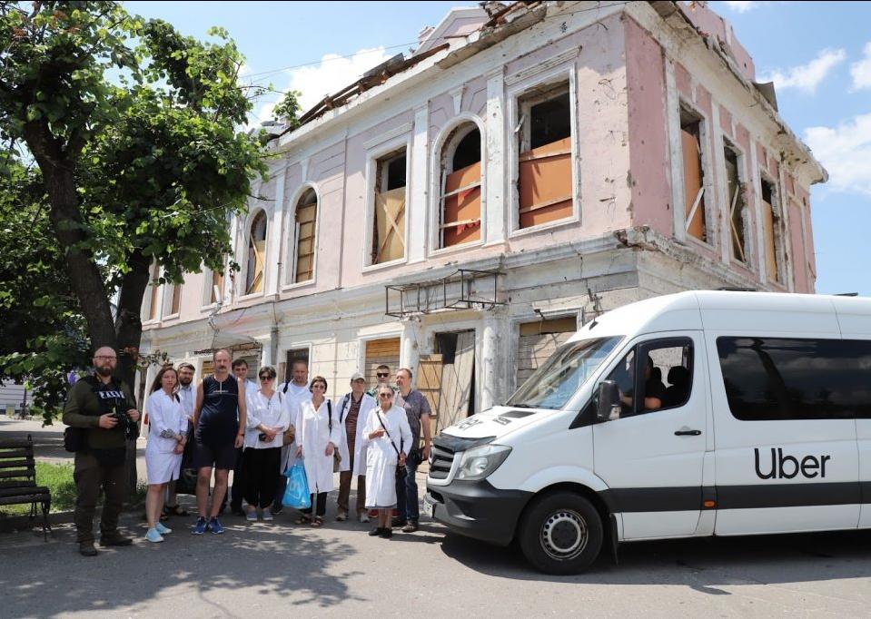 White uber van in front of damaged building