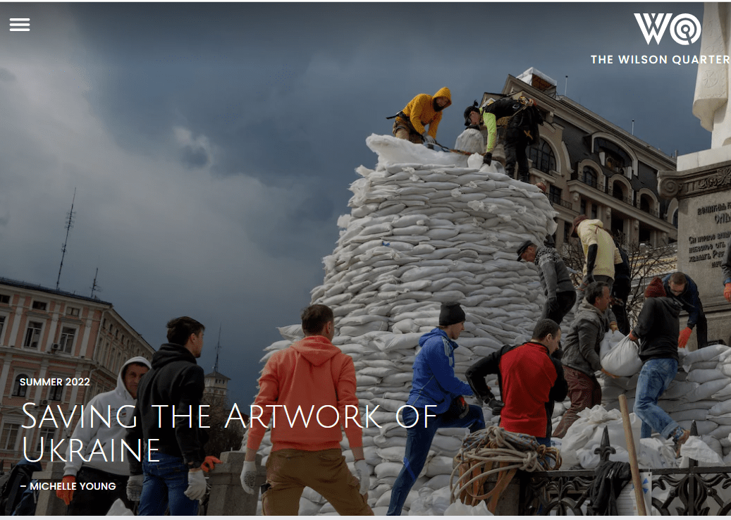 group of people placing white sandbags around the base of a statue