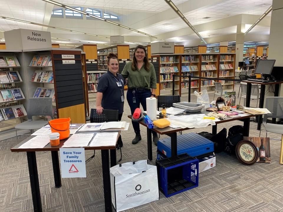 two some stand in front of a table with salvage supplies