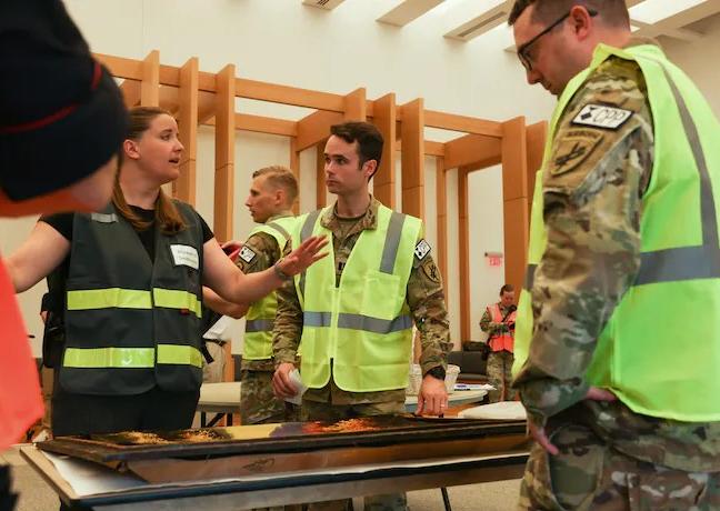 Melissa Weissert, left, discusses the evacuation of cultural objects with Capt. Hayden Bassett, center, during a role-playing exercise at the National Museum of the U.S. Army in Fort Belvoir, Va., on Aug. 10. (Maansi Srivastava/The Washington Post)